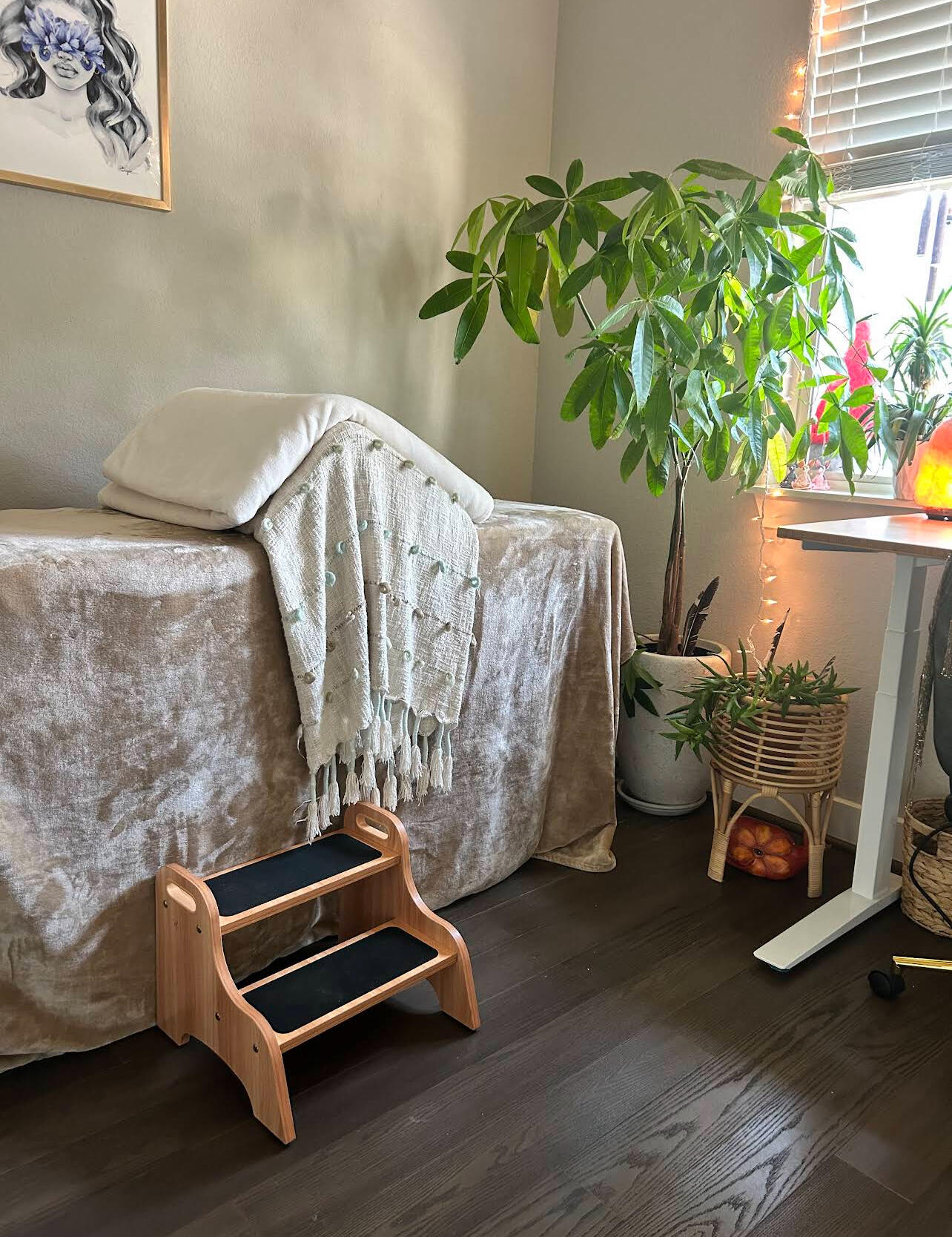 Soul Wanderess session room with massage table, plants, and warm lighting